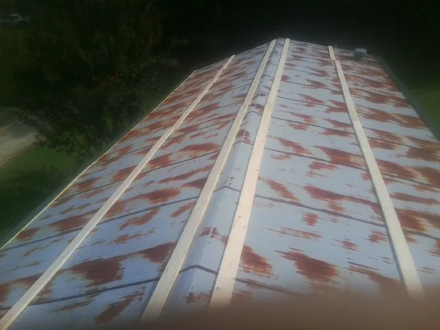 Rusted metal roof panels with new wood purlins before replacement — Storm Damage Roof Repair in Drexel by Roofing Brothers